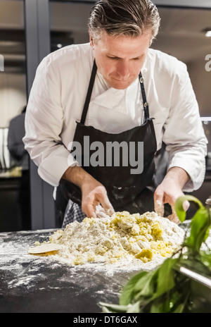 Koch, Gnocchi Teig in Großküche mischen Stockfoto