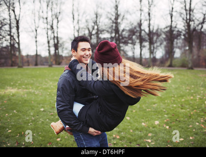 Hübscher junger Mann mit seiner Freundin im Park. Asiatische junge Paar amüsieren sich im Freien. Stockfoto