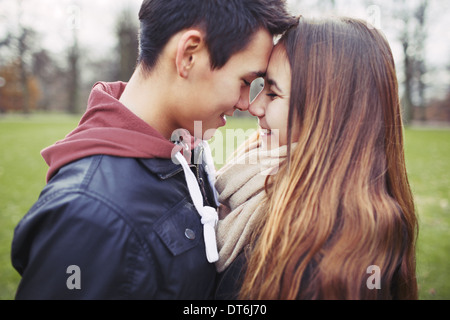 Nahaufnahme von niedlichen Teenager-Paar in Liebe gemeinsam einen besonderen Moment. Romantischer junger Mann und Frau draußen im Park. Stockfoto