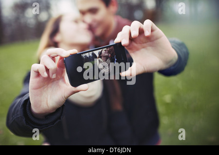 Romantischen Teenager-paar unter Selbstbildnis mit Handy im Park. Junger Mann und Frau in der Liebe. Stockfoto