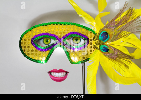 Eine helle gelbe Karnevalsmaske mit gelben Pfauenfedern Stockfoto