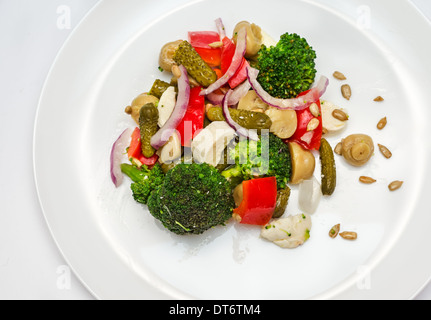 Broccoli-Salat mit Paprika, eingelegte Gurken, Pilzen und Mozzarella. Stockfoto