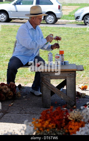 Ein Stallholder, der getrocknete Blumen zum Verkauf neben der Brasilia Metropolitan Cathedral in Brasilia, Brasilien, macht. Stockfoto