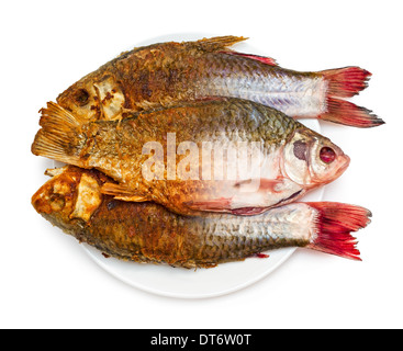 Braten von Fisch. Die Hälfte der Roh- und gebratenen Fisch auf einem Teller, isoliert auf weißem Hintergrund. Stockfoto