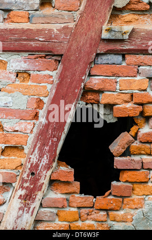Schwarzes Loch in einer roten Backsteinmauer Stockfoto