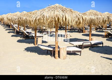 Sonnenschirme und liegen am Strand Stockfoto