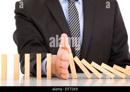 Geschäftsmann Hand Stop Dominosteine kontinuierliche stürzte auf dem Schreibtisch Stockfoto