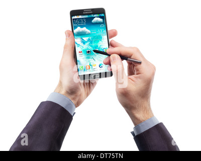 Mannhände mit Samsung Galaxy Note III Smartphone und einen Zeiger auf weißem Hintergrund isoliert Stockfoto