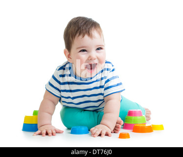 fröhliches Kind spielt mit bunten Spielzeug isoliert auf weiss Stockfoto