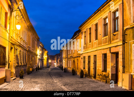 Brasov, Transylvania. Nachtaufnahme des Mittelalters gepflasterte Strasse in der Innenstadt der Stadt. Sächsischer Meilenstein in Rumänien. Stockfoto