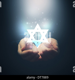 Weibliche Hände öffnen, Licht und Davidstern. Jüdische religion Stockfoto