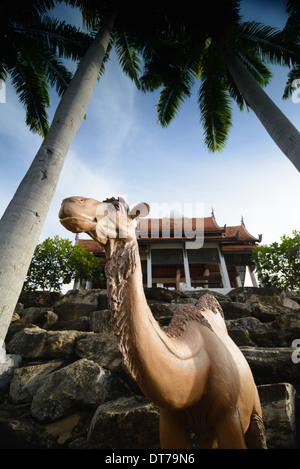 Ein einzelnes Kamel Skulptur unter einer Palme bei Nong Nooch Tropical Garden, Thailand Stockfoto