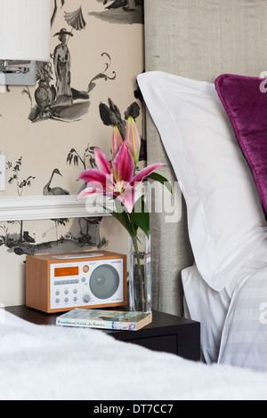 Digitales Radio neben Bett im modernen Schlafzimmer Stockfoto