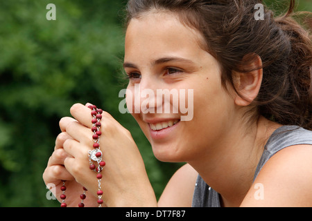 Teenager hält einen Rosenkranz Stockfoto