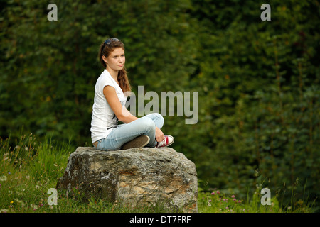 Junges Mädchen auf einem Stein Standortwahl. Stockfoto