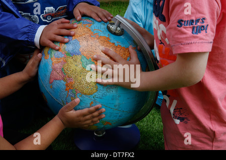 Kinder halten einen Globus Stockfoto