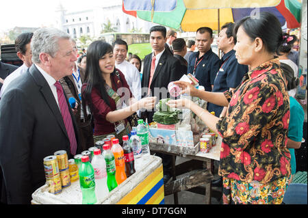 Yangon, Myanmar. 11. Februar 2014. HANDOUT - zeigt ein Handout Bild Bundespräsident Joachim Gauck eine Erklärung von einem Mitarbeiter der deutschen Botschaft ein Myanmars und Straßenverkäufer der richtige Weg, um ein Betel-Urlaub mit Tabasco in Yangon, Myanmar, 11. Februar 2014 Saison anhören. Gauck ist auf eine viertägige Staatsbesuch in Myanmar. Foto: Bundesregierung/Guido Bergmann/Dpa (-. MANDATRORY CREDIT: BUNDESREGIERUNG/GUIDO BERGMANN/DPA) / Dpa/Alamy Live News Stockfoto