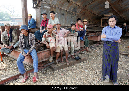 Hafenarbeiter sitzen vor einem Schiff im Bau während einer Taufe von einem umgebauten Passagier Boot, genannt "Schwimmen Ärzte 2" (nicht im Bild), in einer Schiffswerft in der Hauptstadt Yangon, Myanmar, 11. Februar 2014. Das Schiff, das sich im Besitz der Stiftung "Schwimmen Ärzte" war Bapstised durch den Partner im Leben des deutschen Bundespräsidenten Joachim Gauk, Daniela Schadt, und erhält, medizinische Hilfe und Unterstützung in abgelegenen Gebieten und Regionen in Myanmar zu liefern. Deutscher Bundespräsident Gauck ist bei einem viertägigen Besuch in Myanmar. Foto: Wolfgang Kumm/dpa Stockfoto