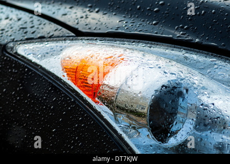 Foto von einem KFZ Scheinwerfer nach einem Regen Stockfoto