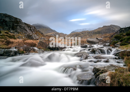 Wasser fließt von Llyn Idwal Cwm Idwal & Tryfan hoch oben in den Hintergrund zu steigen. Stockfoto