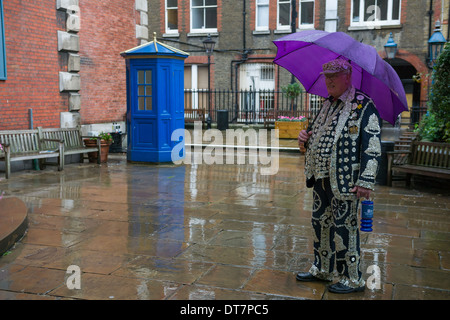 Pearly King mit einem Regenschirm Ankunft für den London Pearly Kings und Queens zweite Erntedankfest, St. Pauls Kirche, Covent Garten, London, England Stockfoto