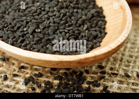 Nigella Sativa (Schwarzkümmel) auf Holzlöffel. Makroaufnahme Stockfoto