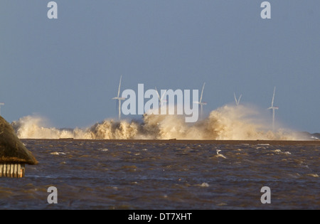 Wellen, die gegen die Reste der Schindel Küstenschutzes mit überschwemmten Sümpfe und teilweise untergetauchten Vogelbeobachtung ausblenden nach Stockfoto