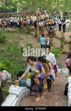 Pilger, die ihren Weg bis zu Wat Tham Phousi mit angeboten, Mount Phousi, Lao Neujahr (Pi Mai Lao), Luang Prabang, Laos Stockfoto