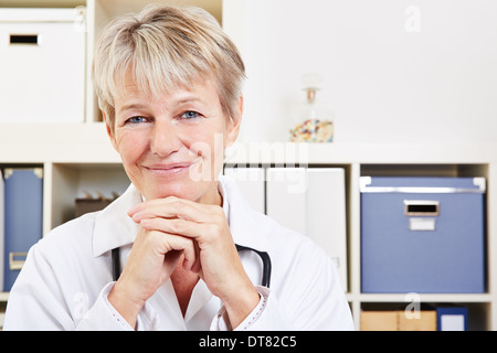 Porträt einer lächelnden älteren Ärztin in ihrem Büro Stockfoto