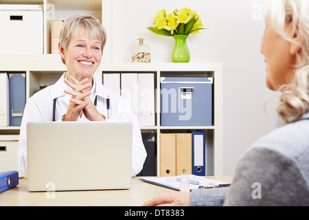 Ärztin im Gespräch mit älteren Patienten in ihrem Büro Stockfoto