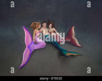 Zwei Meerjungfrauen und ihre Merman in einem Pool in Virginia Beach, Virginia Stockfoto