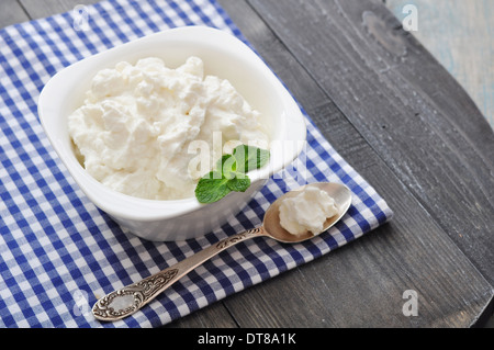 Ricotta-Käse in die Schüssel mit Minze auf hölzernen Hintergrund Stockfoto