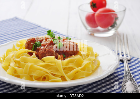 Fleischbällchen mit Pasta und Parmesan in weißer Teller auf hölzernen Hintergrund Stockfoto