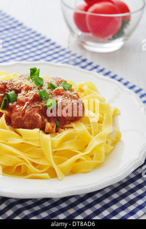Fleischbällchen mit Pasta und Parmesan in weißer Teller auf hölzernen Hintergrund Stockfoto