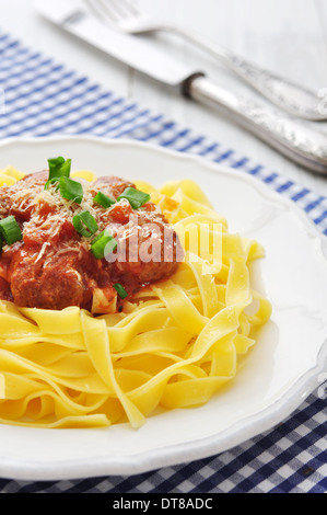 Fleischbällchen mit Pasta und Parmesan in weißer Teller auf hölzernen Hintergrund Stockfoto