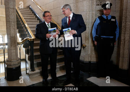 Ottawa, Kanada. 11. Februar 2014. Kanadas Prime Minister Stephen Harper (C) und Finance Minister Jim Flaherty (L) geben den neuen Bundeshaushalt am Parliament Hill in Ottawa, Kanada, 11. Februar 2014 bekannt. Jim Flaherty am Dienstag enthüllt einen föderalen Haushalt einen Überschuss im Jahr 2015 zu projizieren. © David Kawai/Xinhua/Alamy Live-Nachrichten Stockfoto