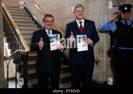 Ottawa, Kanada. 11. Februar 2014. Kanadas Prime Minister Stephen Harper (C) und Finance Minister Jim Flaherty (L) geben den neuen Bundeshaushalt am Parliament Hill in Ottawa, Kanada, 11. Februar 2014 bekannt. Jim Flaherty am Dienstag enthüllt einen föderalen Haushalt einen Überschuss im Jahr 2015 zu projizieren. © David Kawai/Xinhua/Alamy Live-Nachrichten Stockfoto