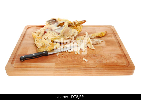 Übrig gebliebene Huhn, Kadaver, abgespeckte Fleisch und einem Küchenmesser auf einem Holzbrett isoliert gegen weiß Stockfoto