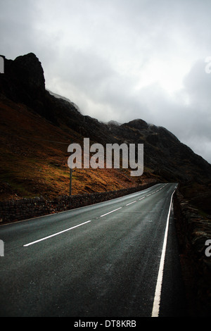 Einsame Straße durch die Berge an einem bewölkten Tag. Stockfoto