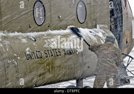 US-Soldaten kehren Schnee von einer CH-47 Chinook-Hubschrauber während eines Schneesturms Winter 6. Februar 2014 in Bagram Air Field, Afghanistan. Stockfoto