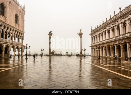 Venedig, Italien. Piazzetta San Marco, St. Marks Platz an einem regnerischen bewölkten Tag mit Spiegelungen auf dem Bürgersteig. Stockfoto