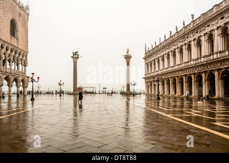 Venedig, Italien. Piazzetta San Marco, St. Marks Platz an einem regnerischen bewölkten Tag mit Spiegelungen auf dem Bürgersteig. Stockfoto