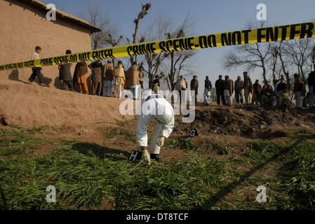 Peshawar, Pakistan. 12. Februar 2014. Pakistanische Sicherheitsbeamte inspizieren die Website eines Angriffs durch militante in Nordwest-Pakistan Peshawar am 12. Februar 2014. Mindestens 10 Personen wurden getötet, als einige unbekannte Kämpfer das Haus eines lokalen Frieden Miliz Kommandanten in Pakistans nordwestlichen Peshawar City stürmten berichteten lokale Medien am Mittwoch Morgen. Bildnachweis: Umar Qayyum/Xinhua/Alamy Live-Nachrichten Stockfoto