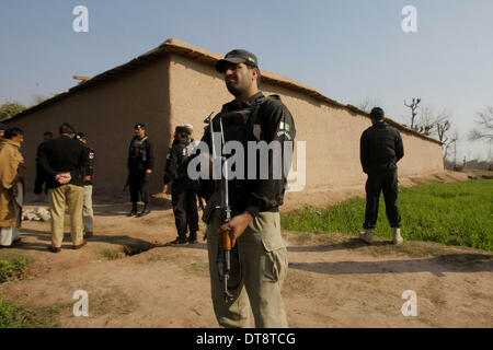 Peshawar, Pakistan. 12. Februar 2014. Pakistanische Sicherheitskräfte bewachen nahe dem Aufstellungsort des Angriffs von Militanten in Nordwest-Pakistan Peshawar am 12. Februar 2014. Mindestens 10 Personen wurden getötet, als einige unbekannte Kämpfer das Haus eines lokalen Frieden Miliz Kommandanten in Pakistans nordwestlichen Peshawar City stürmten berichteten lokale Medien am Mittwoch Morgen. Bildnachweis: Umar Qayyum/Xinhua/Alamy Live-Nachrichten Stockfoto