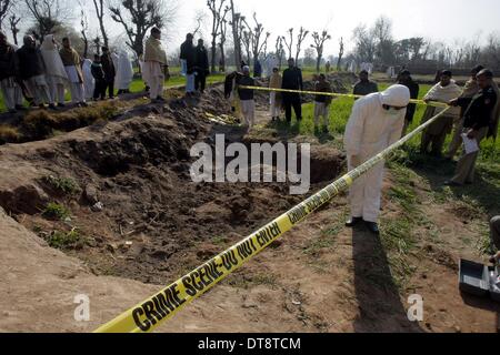 Peshawar, Pakistan. 12. Februar 2014. Pakistanische Sicherheitsbeamte inspizieren die Website eines Angriffs durch militante in Nordwest-Pakistan Peshawar am 12. Februar 2014. Mindestens 10 Personen wurden getötet, als einige unbekannte Kämpfer das Haus eines lokalen Frieden Miliz Kommandanten in Pakistans nordwestlichen Peshawar City stürmten berichteten lokale Medien am Mittwoch Morgen. Bildnachweis: Umar Qayyum/Xinhua/Alamy Live-Nachrichten Stockfoto