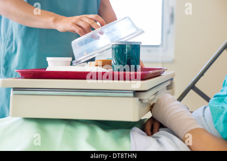 Krankenschwester, heben die Abdeckung aus Fach für Patienten im Krankenhaus Stockfoto