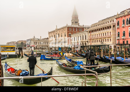 Winter in Venedig, Italien. Venezianische Gondeln und Gondolieri auf der Mole, Ducale, Libreria, S. Zaccaria Wasserbus-Haltestelle, Danieli Excelsior Hotel. Stockfoto