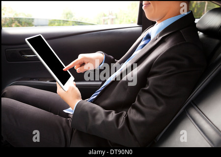 Geschäftsmann, arbeiten hinter dem Auto und mit einer Tablette. mit der Zeit gut Stockfoto