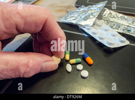 Älterer Mann mit Auswahl an Pillen, Tabletten und Kapseln. Tägliche Dosis des Medikaments. Stockfoto