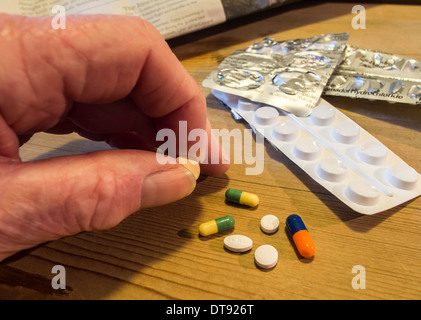 Älterer Mann mit Auswahl an Pillen, Tabletten und Kapseln. Tägliche Dosis des Medikaments. Stockfoto